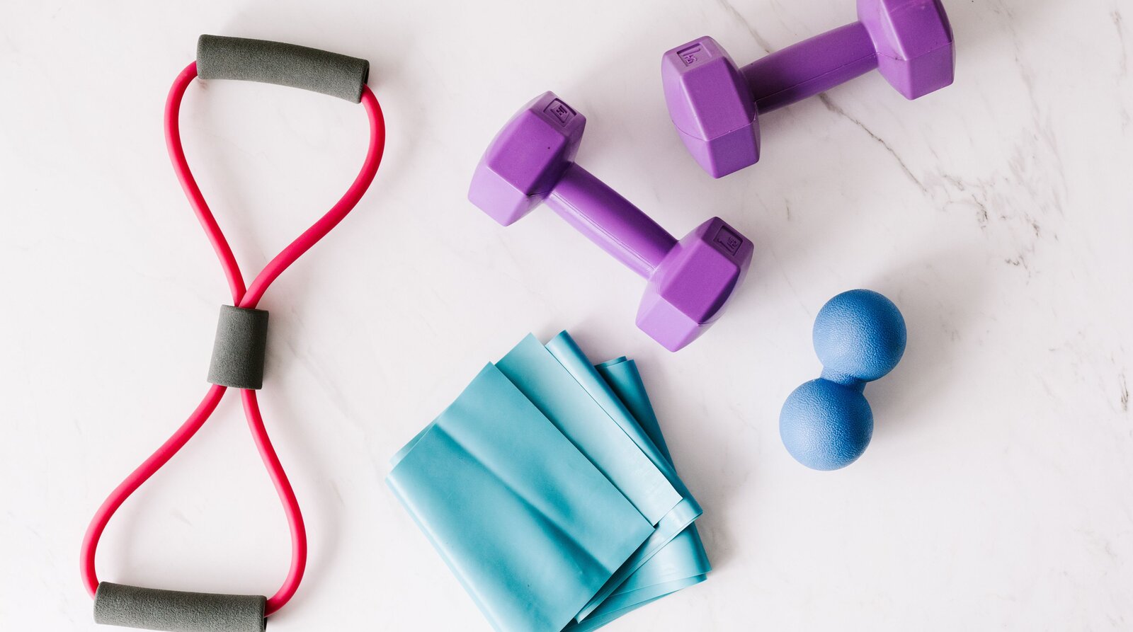 Physiotherapie-Equipment: Widerstandsband, Kurzhanteln und Faszienball